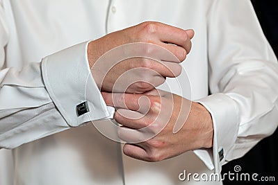 Groom putting on his cufflinks Stock Photo