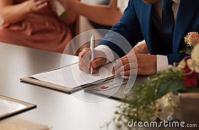 Groom signing marriage certificate Stock Photo