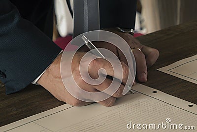 Groom signs the marriage certificate at the end of the ceremony Stock Photo