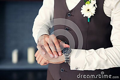 The groom in a waistcoat looking at his watch Stock Photo