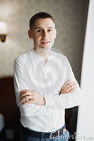 Grooms morning preparation. Handsome man getting dressed and preparing for the wedding Stock Photo