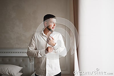 Grooms morning preparation. Handsome man getting dressed and preparing for the wedding Stock Photo