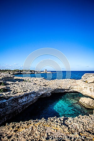 The Grotta della Poesia in the Puglia region of southern Italy with crystal clear blue water and blue sky Stock Photo