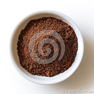 Ground allspice in white ceramic bowl isolated on white from above. Stock Photo