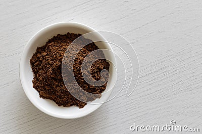 Ground allspice in white ceramic bowl on white wood bac Stock Photo