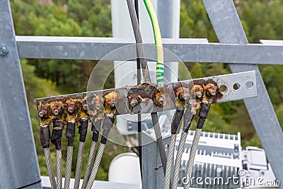 Ground bar with metal hawsers and solid oil for grounding telecommunication equipment of basic station is a part of Stock Photo