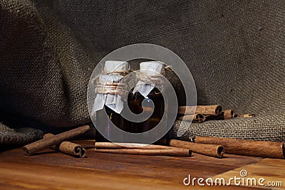 Ground cinnamon, essential oil and cinnamon sticks cinnamon on a darck wooden background. Stock Photo