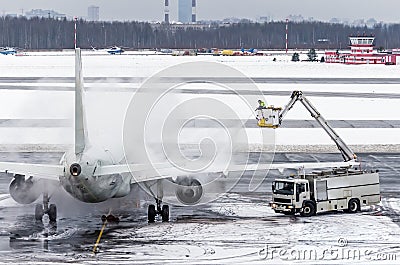 Ground crew provides de icing. They are spraying the aircraft, which prevents the occurrence of frost. Stock Photo