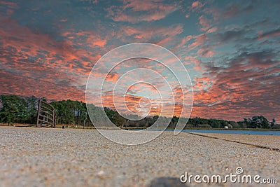 A ground level shot of a blue lake surrounded by lush green trees with blue sky and powerful clouds at sunset at Rhodes Jordan Stock Photo