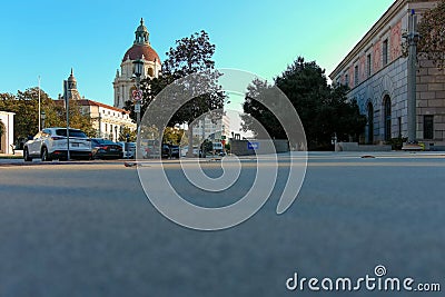 Ground level shot of a office buildings, apartments, city hall and parked cars along the street with lush green trees and a clear Editorial Stock Photo