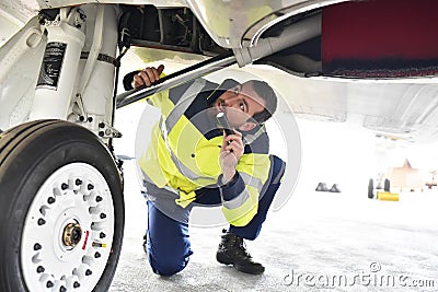 Ground personnel at the airport check the hydraulic system of th Stock Photo