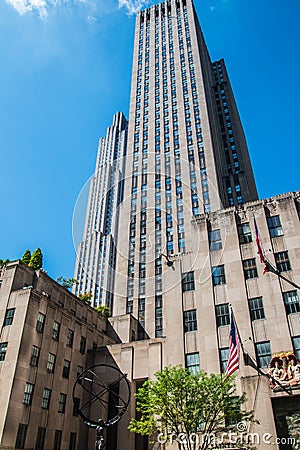 Ground view looking up at a large New York City skyscraper. The statue of Atlas is at the base of this Rockefeller Plaza building Editorial Stock Photo