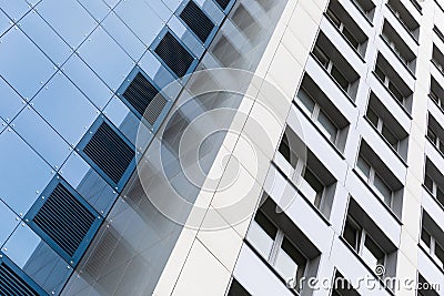 Ground view of tall modern building facade, blue and white smooth facade surface. Stock Photo