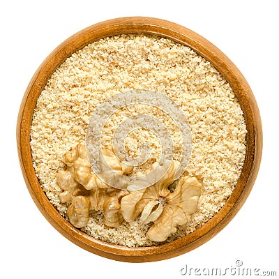 Ground walnuts and walnut kernel halves in wooden bowl Stock Photo