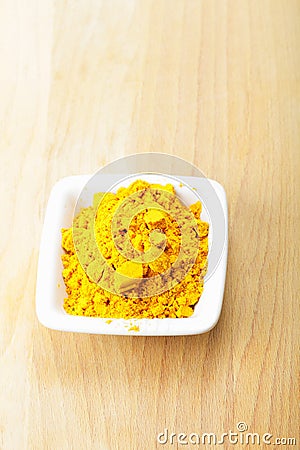 Grounded saffron spice in white dish on wood Stock Photo