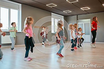 Repeat after me. Group of active children dancing in front of the large mirror while having choreography class in the Stock Photo