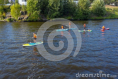 Group of active tourists stand up paddling on sup boards Editorial Stock Photo