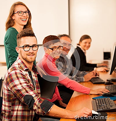 Group of adults learning computer skills. Intergenerational tran Stock Photo