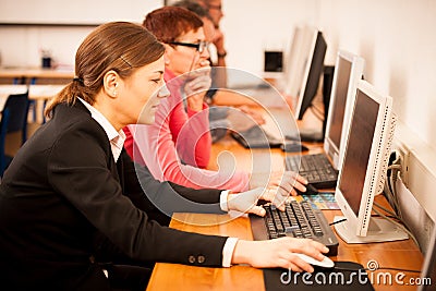 Group of adults learning computer skills. Intergenerational tran Stock Photo