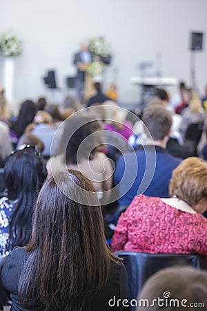 Group of Adults Listening to the Host on Stage Editorial Stock Photo