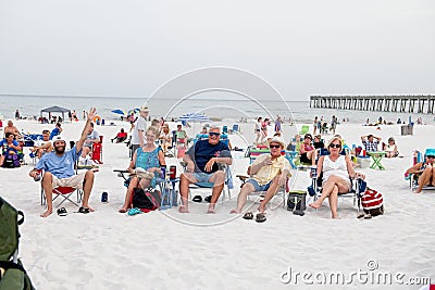A group of adults sit in beach chairs on the sand at Pensacola. Beach, Florida Editorial Stock Photo