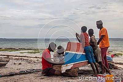 Group of African people fixing and maintaining fisherman's colorful wooden boat, at the shore of Indian Ocean Editorial Stock Photo