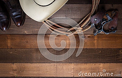 American Cowboy Items incluing a lasso spurs and a traditional straw hat on a wood plank background Stock Photo