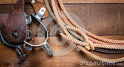 American Cowboy Items incluing a lasso spurs and a traditional straw hat on a wood plank background Stock Photo