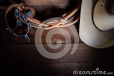 American Cowboy Items incluing a lasso spurs and a traditional straw hat on a wood plank background Stock Photo