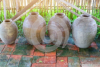 A group of ancient earthenware containers for placing water on brick floors, vintage tone images Stock Photo