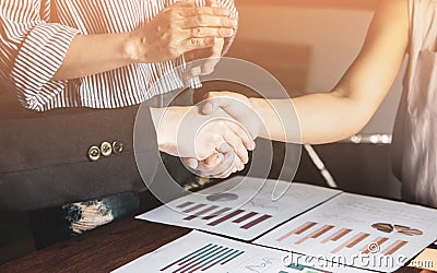 Group asia businessman woman shakehand together create a mutually beneficial business relationship. Economic graph on the table Stock Photo