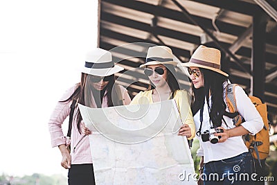 Group of asia women traveler and tourist traveling backpack holding map and waiting in a train station platform, vintage tone Stock Photo