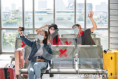 Friends in face masks selfie at airport terminal Stock Photo