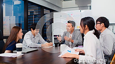 Group of Asian business people discuss together in team brainstorm meeting, work late night in office Stock Photo