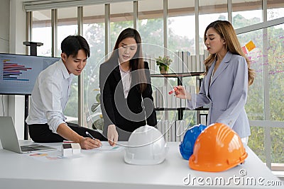 Group of Asian businesspeople and engineers working and brainstorming in office. Competent construction team having discussion Stock Photo