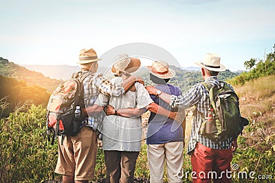 A group of Asian elders climbing and standing on high mountains Stock Photo