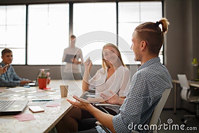 Group of attractive entrepreneurs in meeting with bright windows and cluttered conference table. Stock Photo