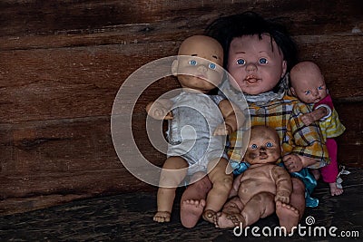 A group of baby dolls sitting in an old wooden house Stock Photo