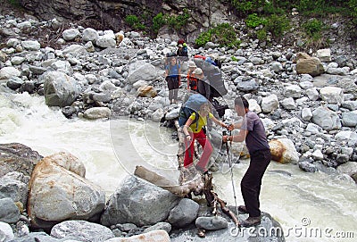 Group of backpacker tourists crossing river Editorial Stock Photo