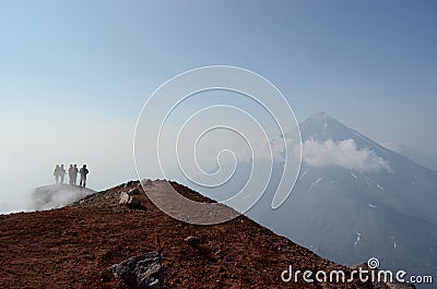 A group of backpackers standing at the top of volcano Stock Photo