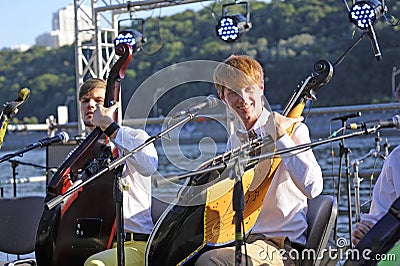 Group of bandurists playing ethno music on the beach, Dnipro river on a background. Bandura - Ukrainian national musical Editorial Stock Photo