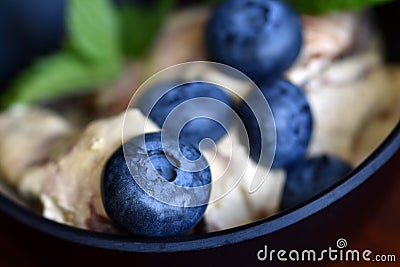 Group of blueberries on ice cream in dark bowl closeup Stock Photo