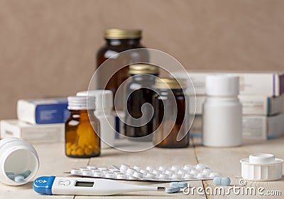 A group of boxes of medicines, pill bottles, thermometer and blisters of pills Stock Photo