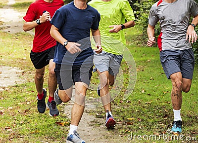 Group of boys running together on grass path Stock Photo