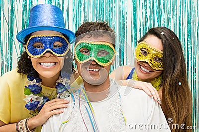 Group of Brazilian friends wearing Carnaval costume. Masked revelers pose for the photo.. Stock Photo