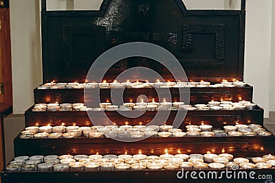 Group of burning candles on church altar close-up in christian catholic church, flaming candles, funeral, faith and memory concept Stock Photo