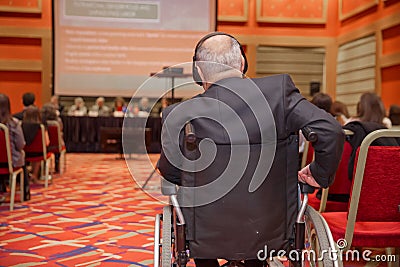 Man with headset at the conference . The audience wearing head phone for online translation . Unrecognizable people using in ear Editorial Stock Photo
