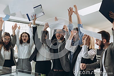 Group of business people celebrating by throwing their business papers and documents fly in air, Power of cooperation, Success Stock Photo