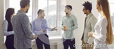 Group of business people chatting after a meeting. Company employees talking in the office. Stock Photo