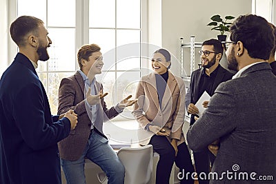 Group of business people chatting after a meeting. Company employees talking in the office. Stock Photo